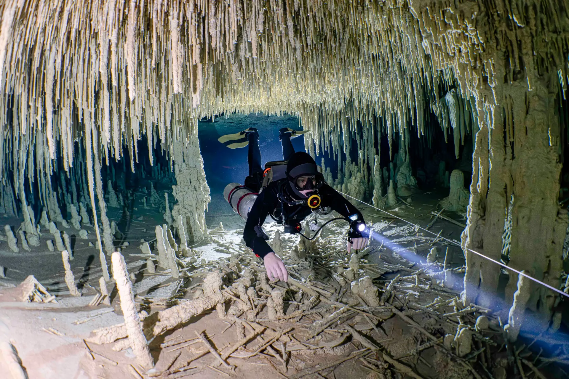 Cave diver moving carefully through a protected cenote